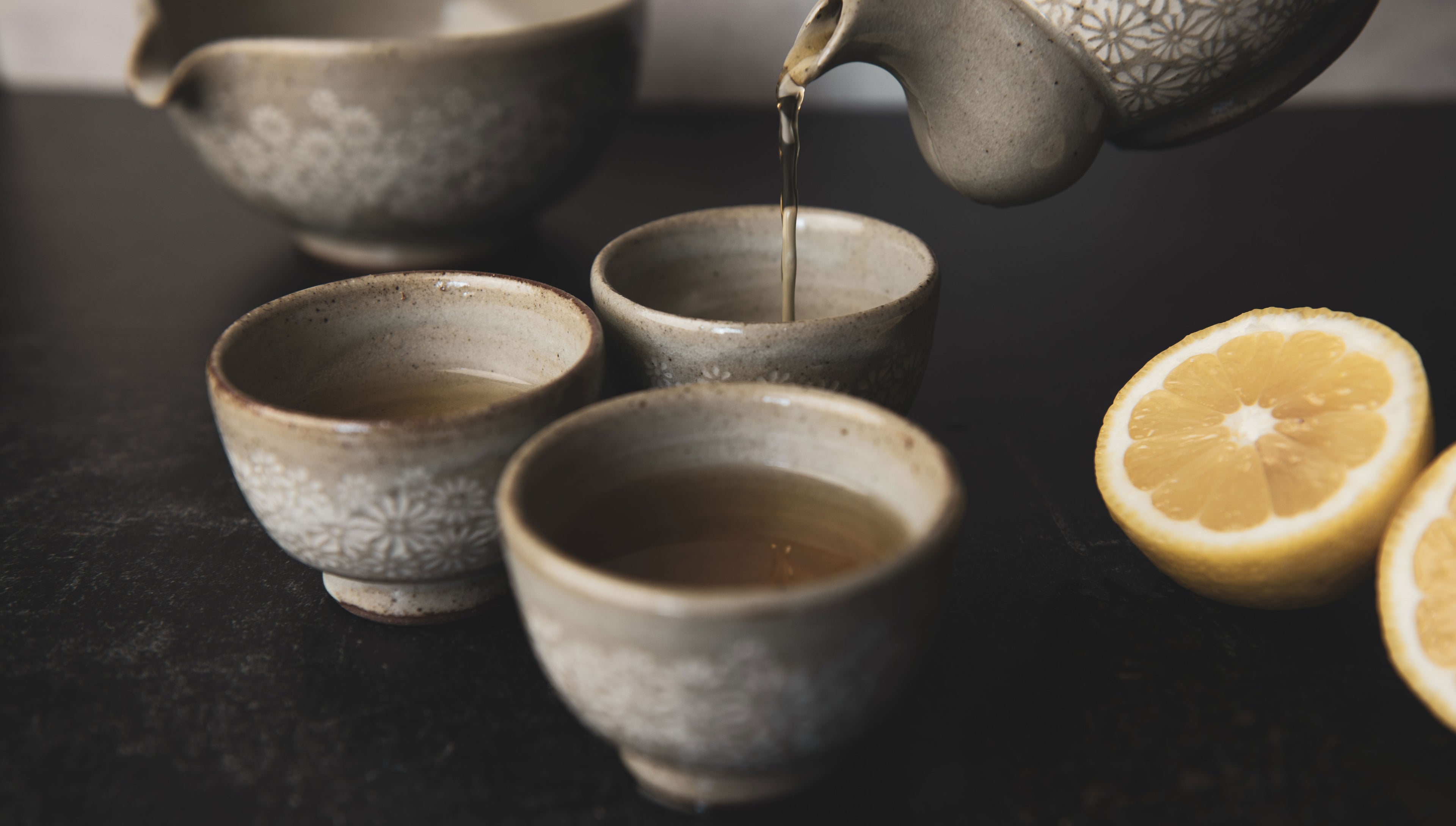 Tea being poured into ceramic tea cups
